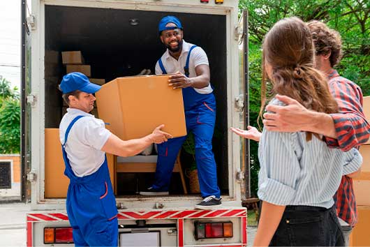 A man and woman are seen loading boxes into a moving truck, indicating a process of moving safes and heavy items.