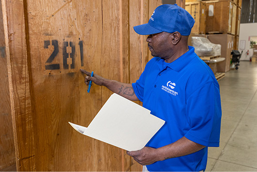 A man in a blue shirt with a clipboard, illustrating Long-Term Storage Solutions in San Marcos.
