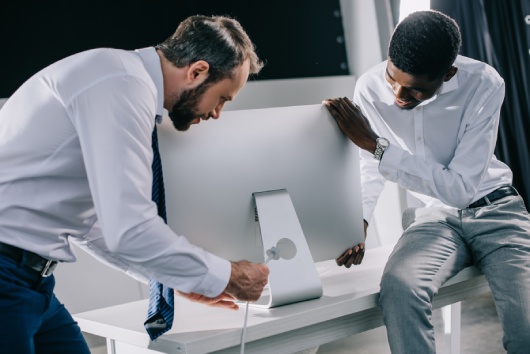 multiethnic businessman connecting desktop computer in new office